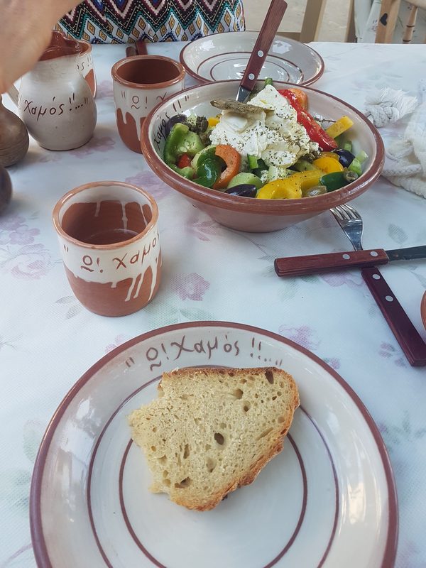 A Greek salad with feta, peppers, olives and capers served with fresh bread at a Milos taverna