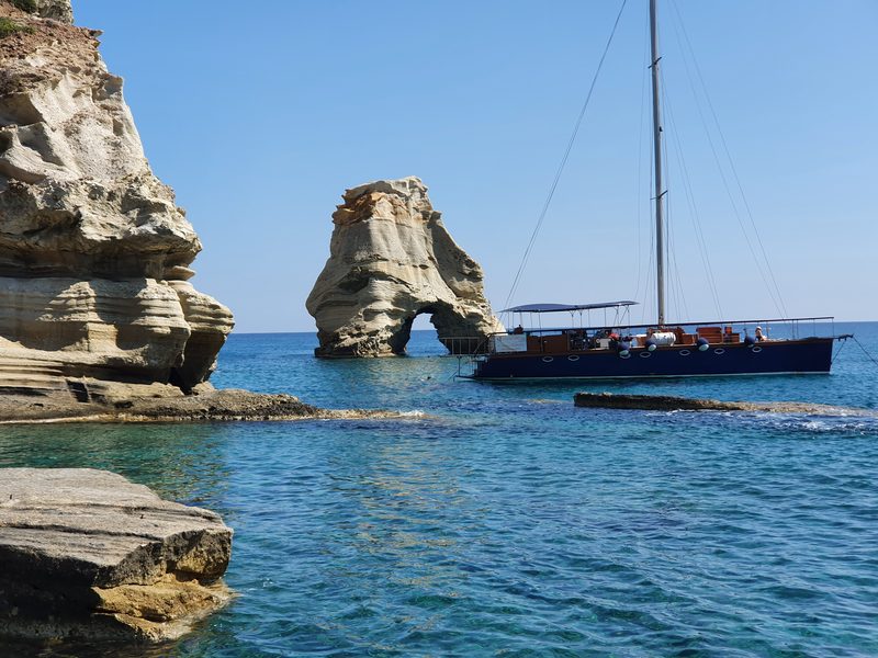 A limestone sea arch rising from clear water at Kleftiko on the Milos coast